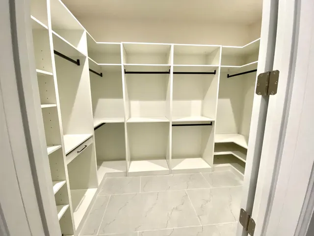 a view of walk in closet with empty racks