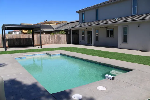 a view of a house with a yard and sitting area