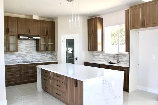 a kitchen with stainless steel appliances granite countertop a sink and a refrigerator