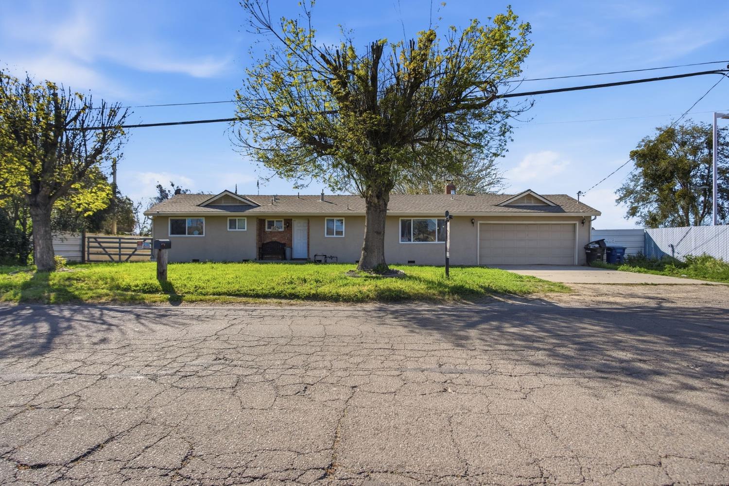 1409 Stonum Road Modesto, CA 95351 - Photo 1 of 40 a front view of a house with a garden and trees