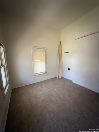 an empty room with windows and closet
