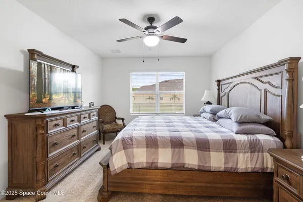 a bedroom with a bed and dresser with mirror
