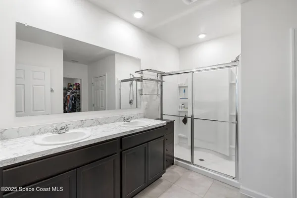 a bathroom with a double vanity sink mirror and shower