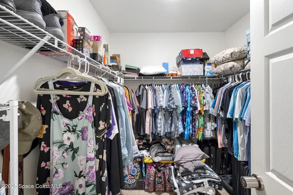 a view of walk in closet with clothes