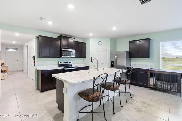 a large kitchen with kitchen island granite countertop a counter top space appliances and a center island