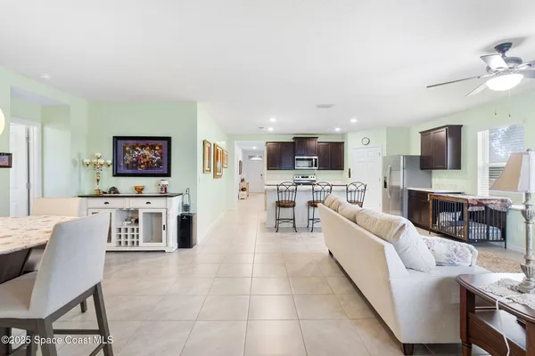 a living room with furniture a flat screen tv and kitchen view