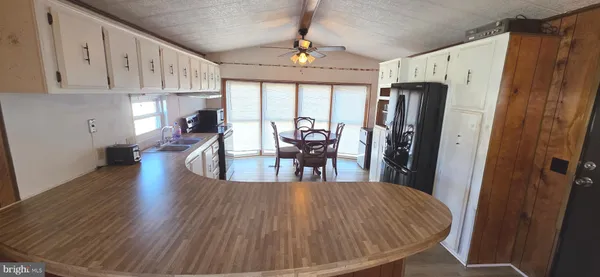 a dining room with wooden floor a chandelier a wooden table and chairs