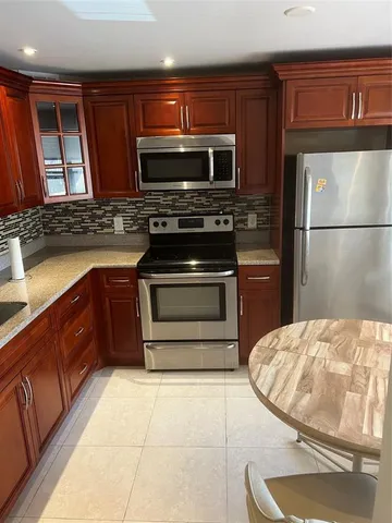 a kitchen with stainless steel appliances granite countertop a stove microwave and sink