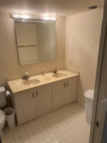 a bathroom with a sink vanity mirror and toilet