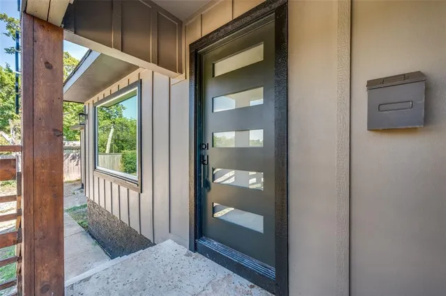 a view of a hallway with a door and wooden floor