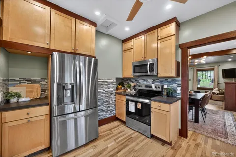 a kitchen with stainless steel appliances granite countertop a refrigerator stove and sink