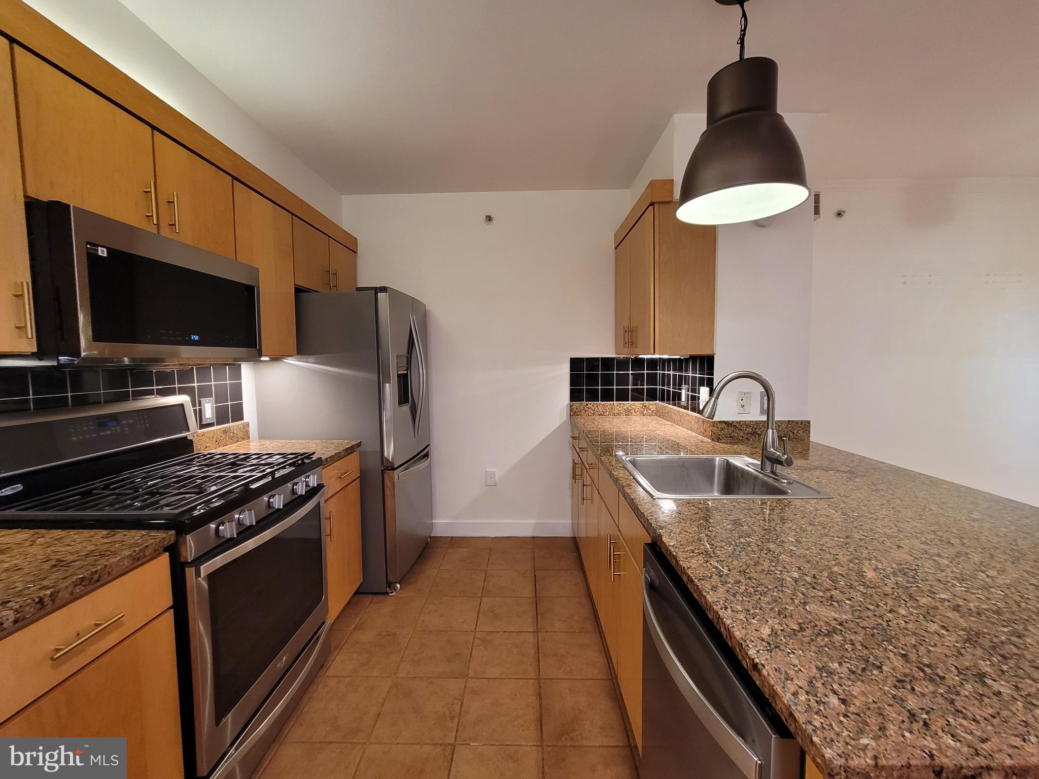 616 E Street Northwest, Unit 1007 Washington, DC 20004 - Photo 5 of 99 a kitchen with granite countertop a stove and a sink