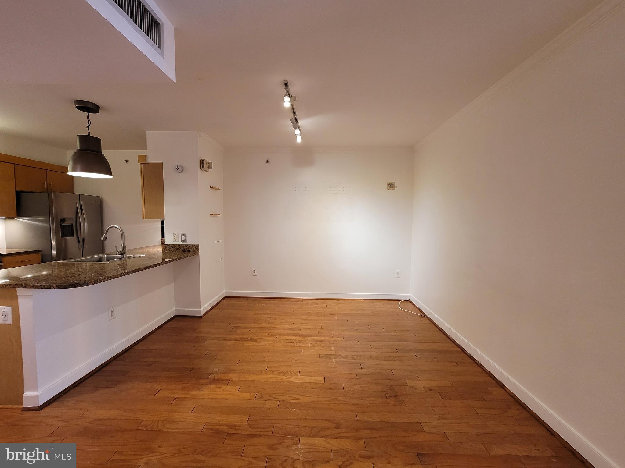 616 E Street Northwest, Unit 1007 Washington, DC 20004 - Photo 8 of 99 a view of kitchen and empty room with wooden floor