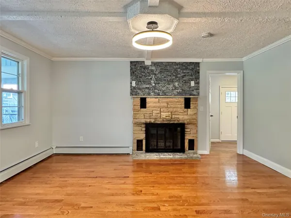 an empty room with fireplace wooden floor and windows