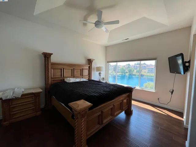a living room with kitchen island granite countertop wooden floor and a large window