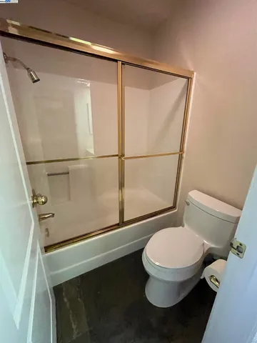 a bathroom with a granite countertop sink mirror and toilet