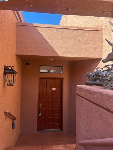 a view of building along with potted plants and large tree