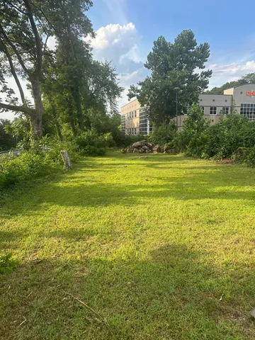a large body of water with a big yard and large trees