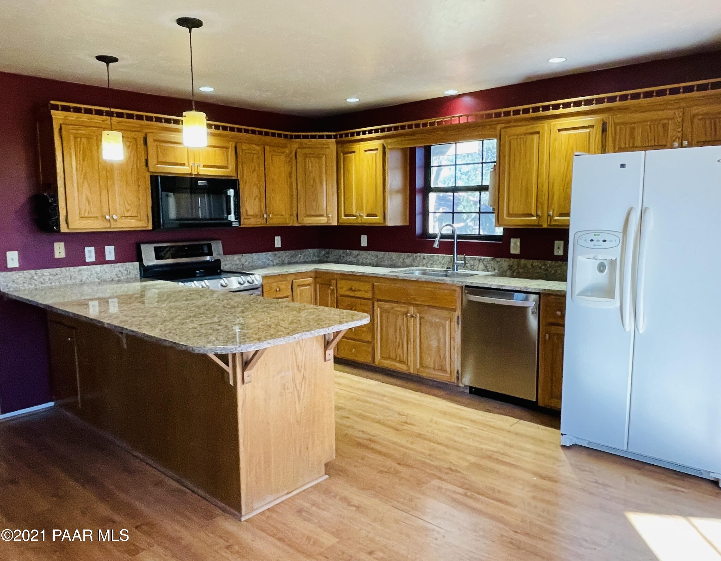 2895 North Reed Road Chino Valley, AZ 86323 - Photo 12 of 40 a kitchen with stainless steel appliances granite countertop a stove a sink and a refrigerator