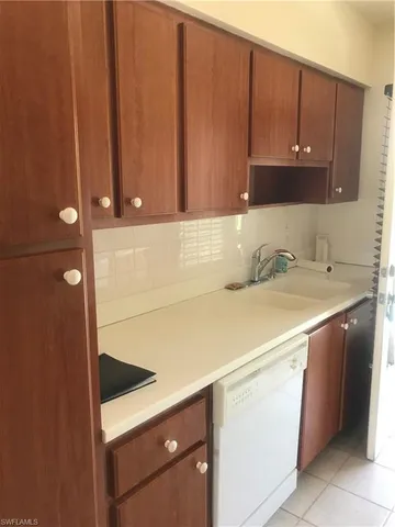a kitchen with a sink a stove cabinets and a window