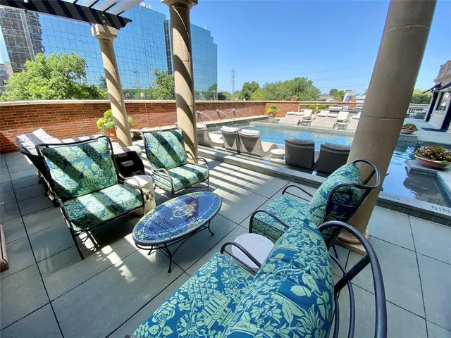 a roof deck with couches and potted plants