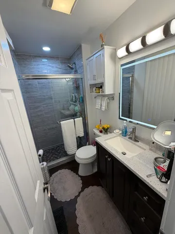a bathroom with a double vanity sink toilet and mirror