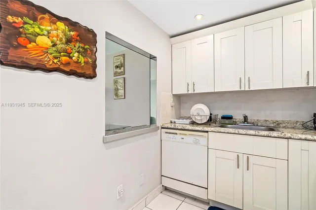 a kitchen with granite countertop white cabinets and sink