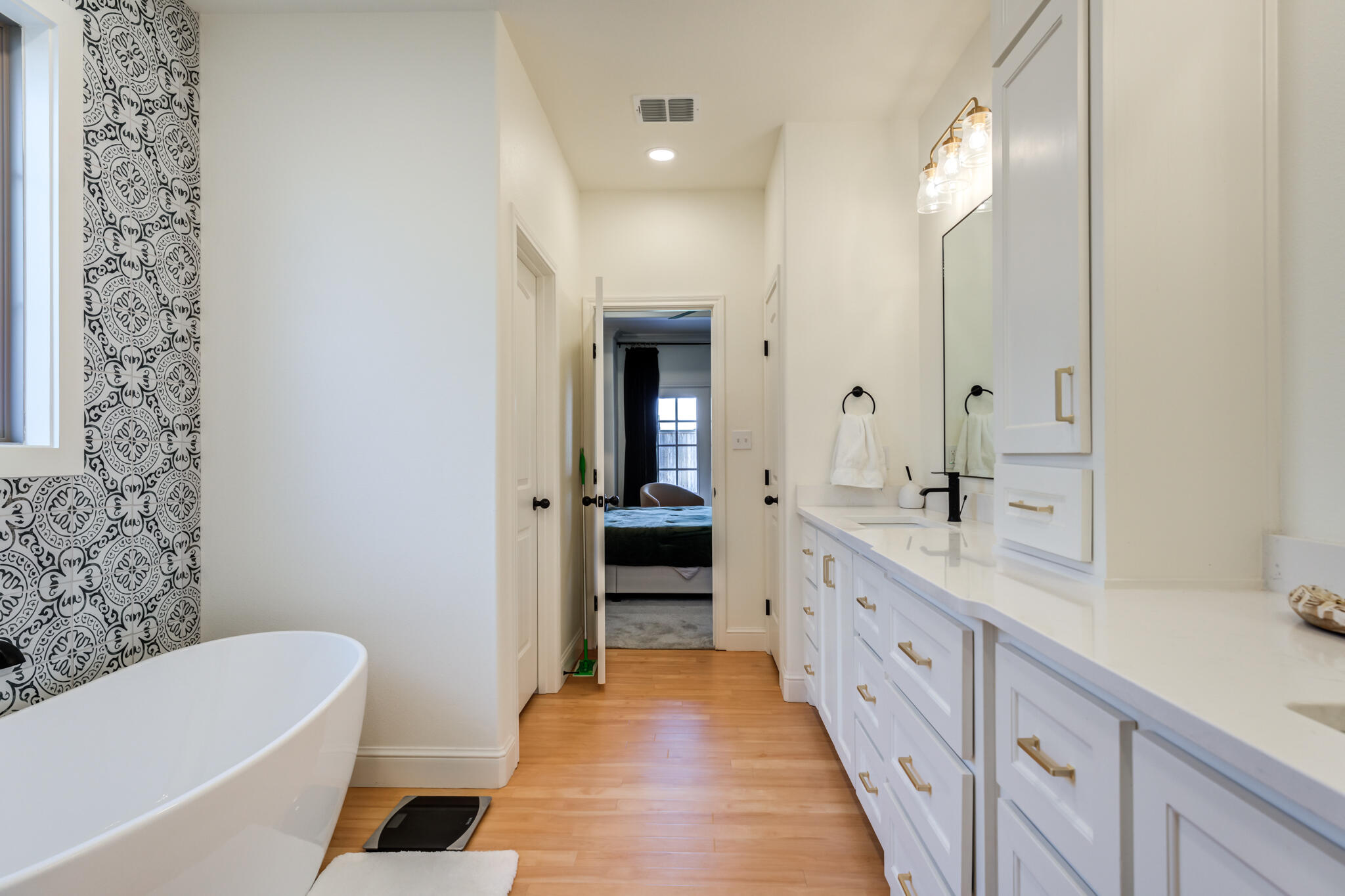 7819 55th Street Lubbock, TX 79407 - Photo 33 of 39 a bathroom with a double vanity sink and mirror with bathtub
