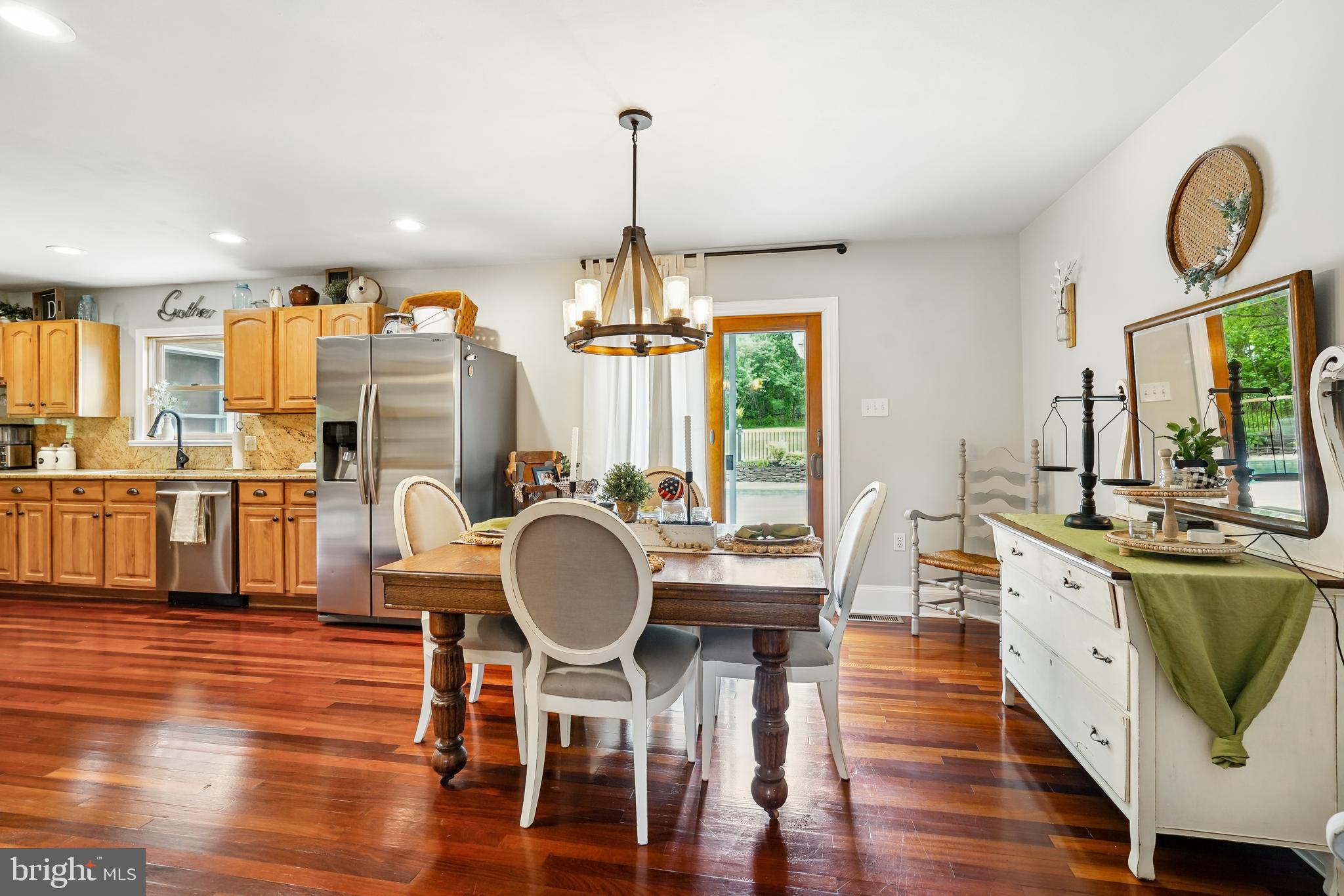 410 Star Rte Road Elkton, MD 21921 - Photo 15 of 40 a dining room with wooden floor a chandelier a wooden table and chairs