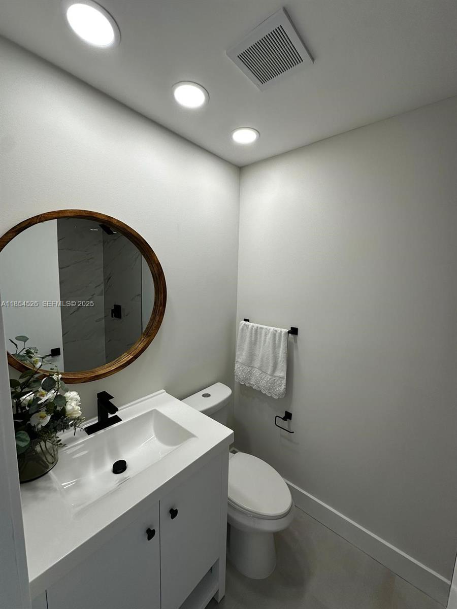 316 Cape Cod Circle, Unit B Lake Worth, FL 33467 - Photo 15 of 38 a bathroom with a sink mirror and toilet
