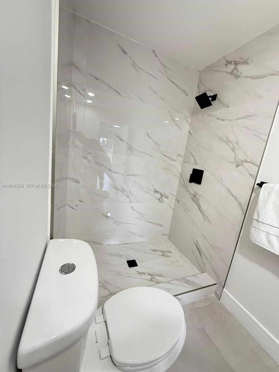 316 Cape Cod Circle, Unit B Lake Worth, FL 33467 - Photo 18 of 38 a bathroom with a toilet and a shower