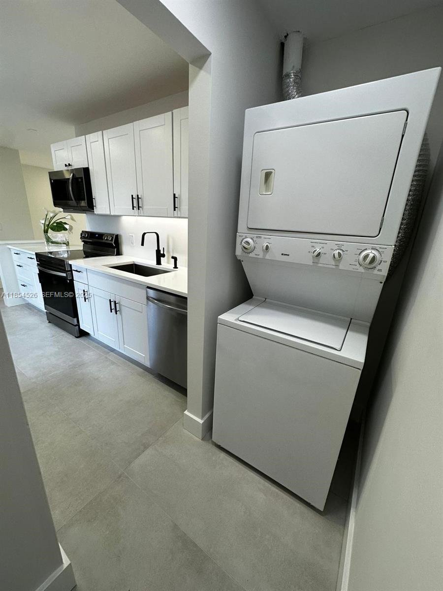 316 Cape Cod Circle, Unit B Lake Worth, FL 33467 - Photo 19 of 38 a kitchen with a refrigerator sink stove and cabinets