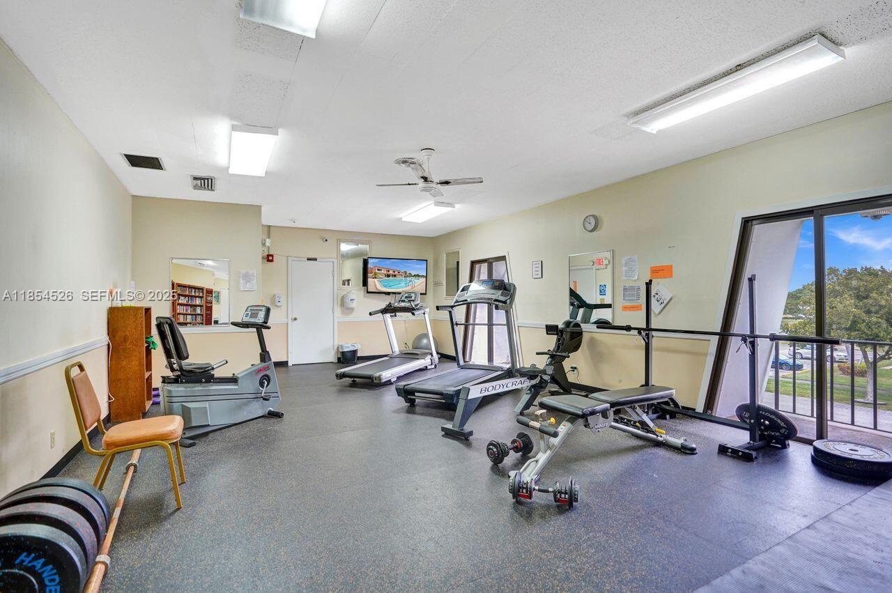 316 Cape Cod Circle, Unit B Lake Worth, FL 33467 - Photo 35 of 38 a view of a livingroom with gym equipment