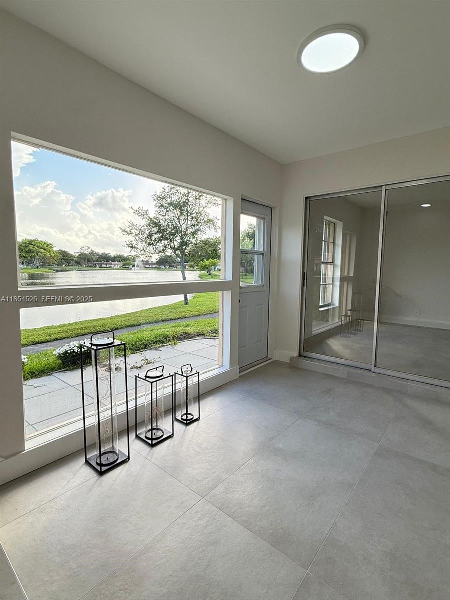 316 Cape Cod Circle, Unit B Lake Worth, FL 33467 - Photo 8 of 38 an empty room with floor to ceiling windows and yard