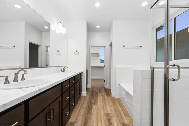 a spacious bathroom with a double vanity sink a mirror and shower
