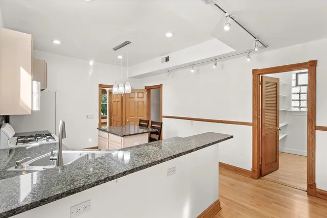 a kitchen with granite countertop a sink and a refrigerator