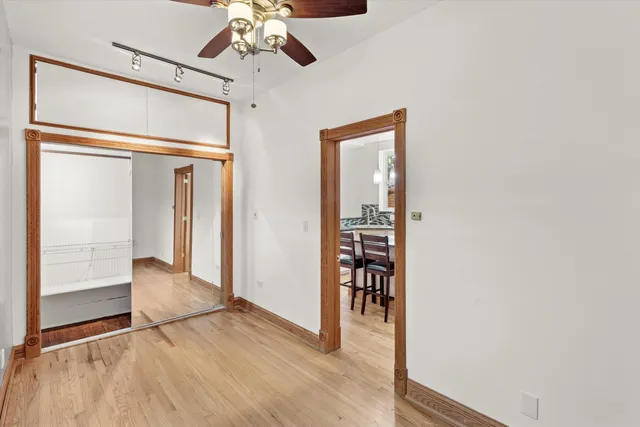 a view of a hallway with wooden floor and chandelier