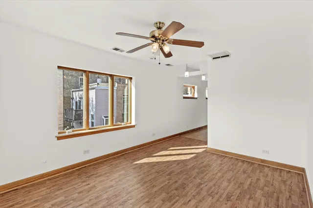a view of a livingroom with wooden floor and a ceiling fan