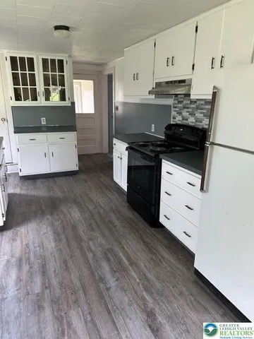 a kitchen with granite countertop white cabinets and white appliances