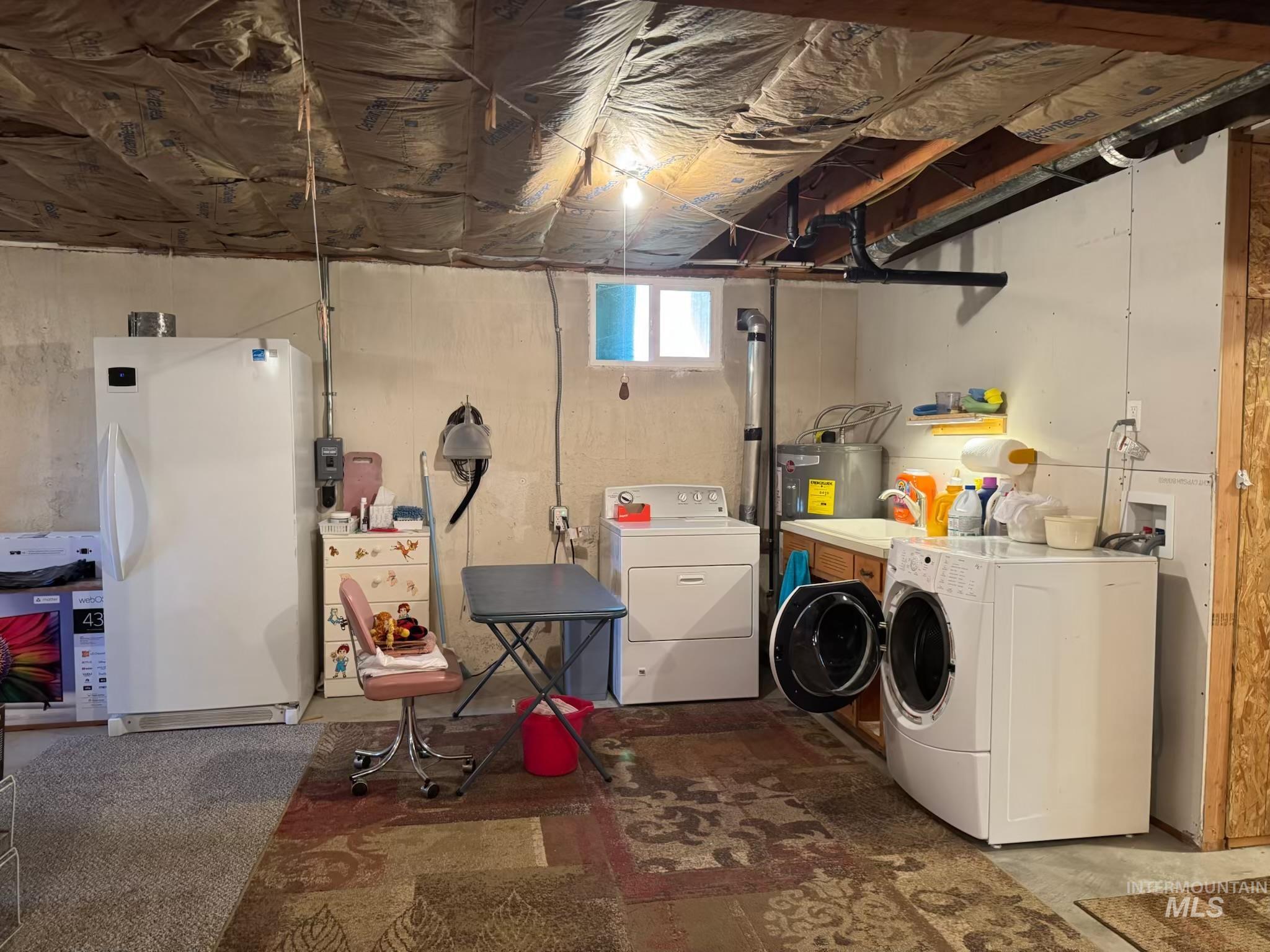 643 South Main Street Cascade, ID 83611 - Photo 26 of 38 Laundry area featuring washer and clothes dryer, concrete floors, and water heater