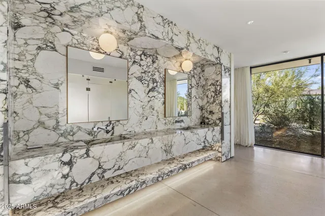a spacious bedroom with a large bed a chandelier and closet