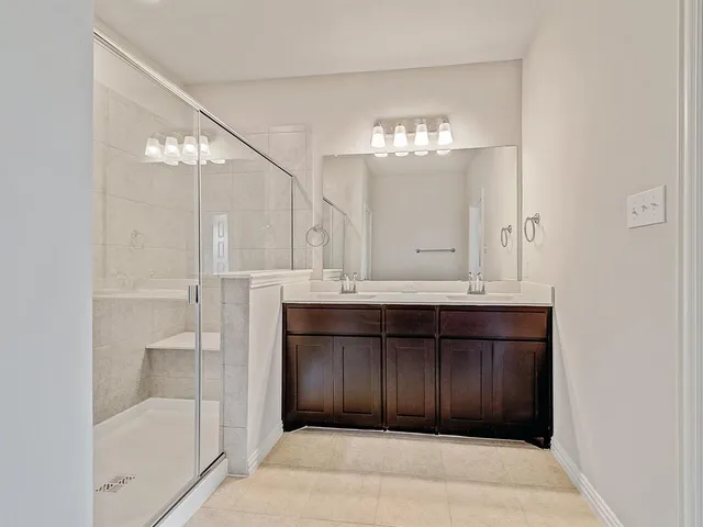 a bathroom with a shower sink and mirror
