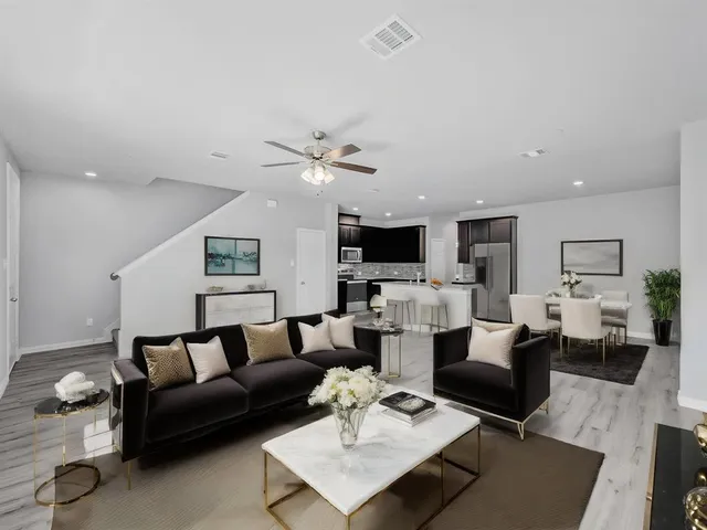 a living room with furniture kitchen view and a flat screen tv