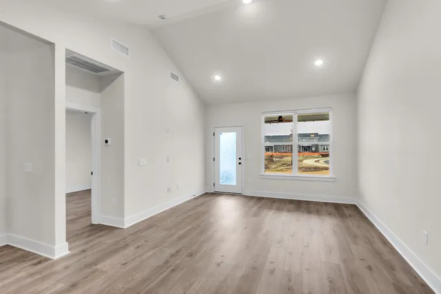 an empty room with wooden floor and window