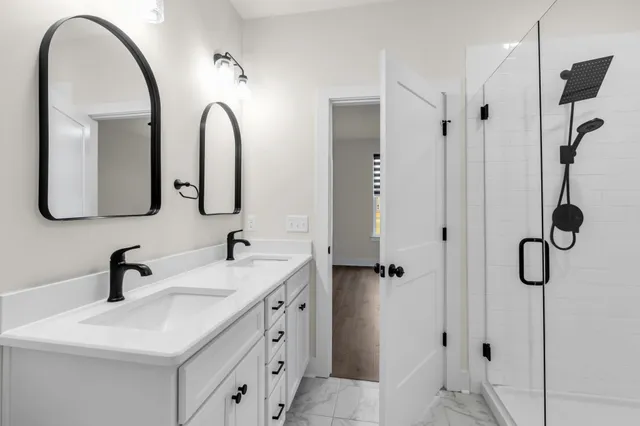 a bathroom with a double vanity sink mirror and shower