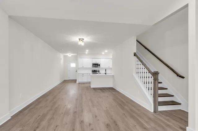 a view of a kitchen with wooden floor and electronic appliances