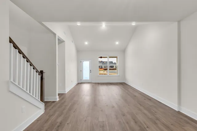 a view of a hallway with wooden floor and windows