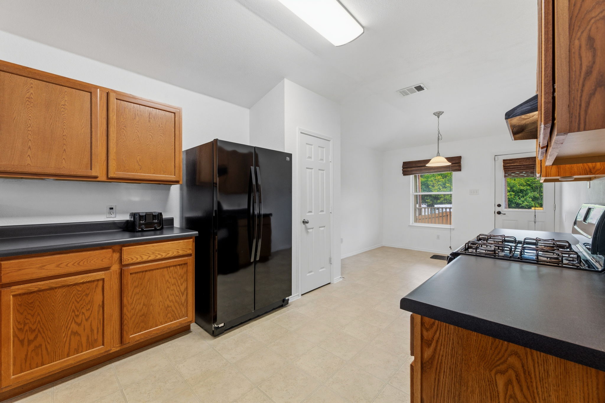 12601 Waynespur Lane Elgin, TX 78621 - Photo 20 of 38 A well-appointed kitchen showcasing durable countertops and natural wood cabinetry.