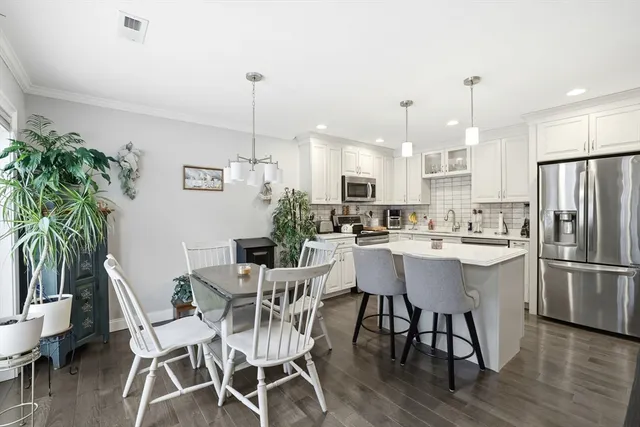 a kitchen with refrigerator and chairs