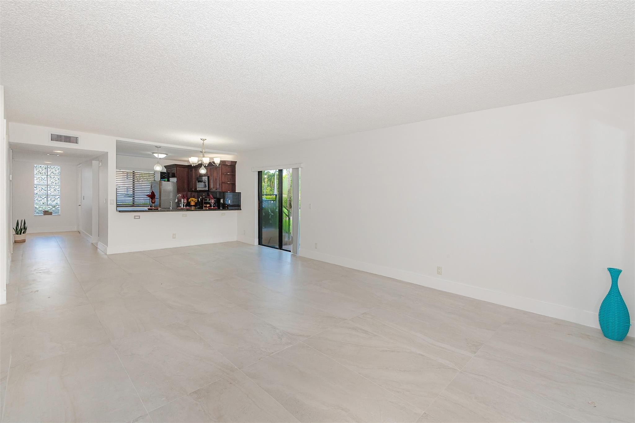 340 Racquet Club Road, Unit 101 Weston, FL 33326 - Photo 6 of 29 a view of a livingroom and a kitchen space with furniture